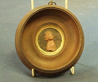 An 18th Century embossed wax head and shoulders portrait of a gentleman 2" contained in a turned socle frame