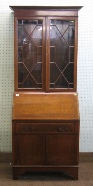 An Edwardian inlaid mahogany bureau bookcase, the upper section with moulded cornice enclosed by astragal glazed panelled doors, the base fitted a fall front revealing a fitted interior above 1 long drawer and double cupboard enclosed by panelled door, raised on bracket feet 30"
