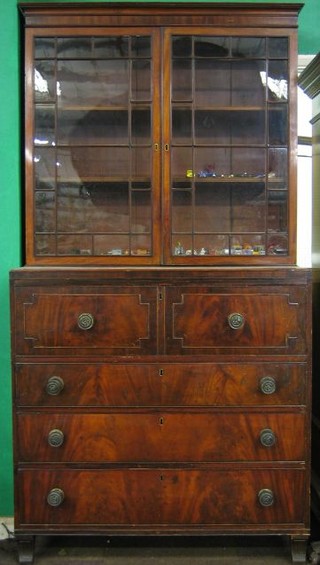 A  Georgian mahogany secretaire bookcase, the upper section with moulded cornice, fitted adjustable shelves enclosed by astragal glazed panelled doors, the secretaire drawer revealing a well fitted interior above 3 long drawers with embossed brass tore handles, raised on turned supports 42"