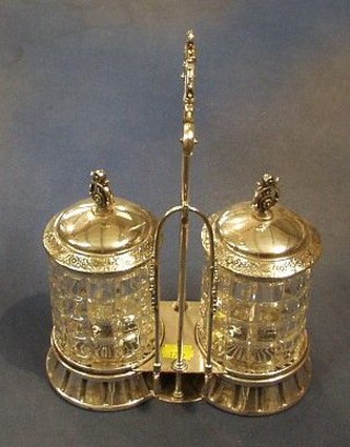 A silver plated and cut glass 2 bottle pickle stand with hobnail cut bottles, contained in a pierced plated mount