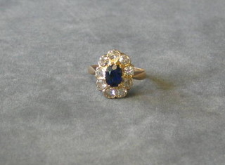 An 18ct gold dress ring set an oval cut sapphire surrounded by 9 diamonds