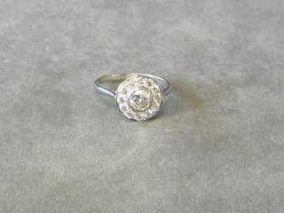 An Art Deco style dress ring set a circular cut diamond supported by 13 diamonds (approx 0.95ct)