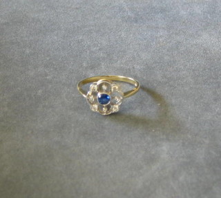 A lady's white gold dress ring  set a circular cut sapphire surrounded by diamonds