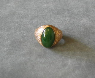 An Oriental high carat gold ring set a cabouchon cut jade coloured stone