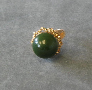 An Oriental gold dress ring set a cabouchon cut jade coloured stone