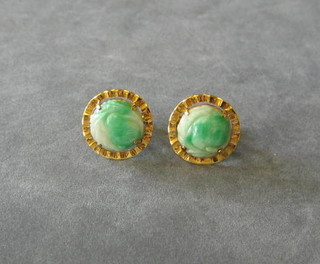 A pair of Oriental 18ct gold cufflinks set jade coloured carved stones