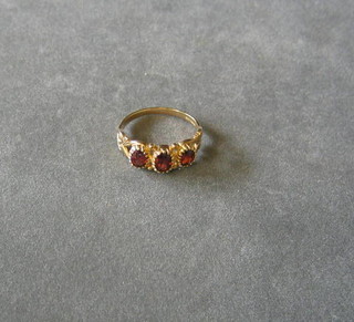 A gold dress ring set 3 oval cut red stones