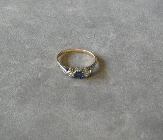 A lady's gold dress ring set sapphire and 2 illusion set diamonds