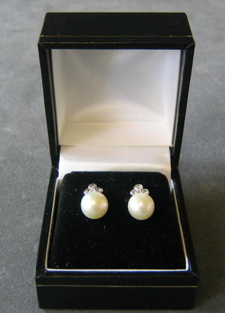 A pair of lady's pearl earrings surmounted by 3 diamonds