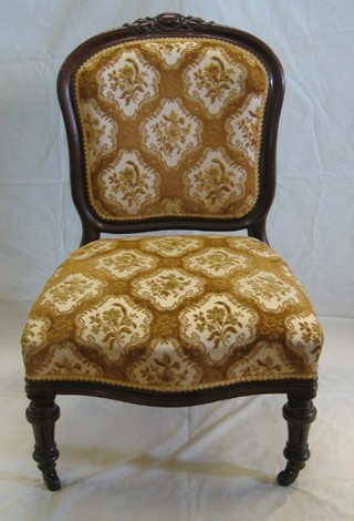 A  Victorian mahogany show frame nursing chair with carved cresting rail and upholstered seat, on turned supports