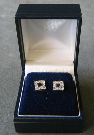A pair of lady's white gold ear studs set square cut sapphires supported by diamonds