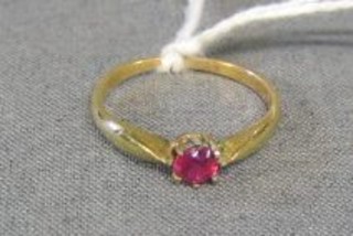 A gold ring set a red stone