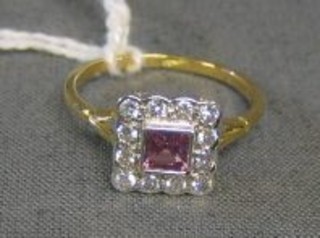 A lady's gold dress ring set a square cut pink sapphire surrounded by 12 diamonds