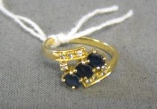 A lady's 18ct gold dress ring set 3 oval cut sapphires supported by 8 diamonds