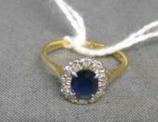 A lady's 18ct gold dress ring set an oval cut sapphire surrounded by diamonds