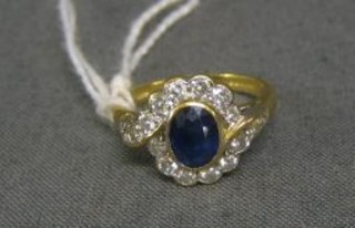 A lady's gold dress ring set an oval cut sapphire surrounded by 16 diamonds