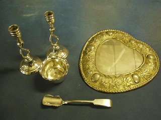 An oval embossed silver plated heart shaped mirror 10", a pair of silver plated spiral turned candlesticks 7", a silver plated Old English pattern stilton scoop and a sugar bowl