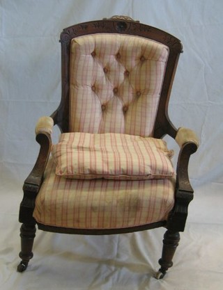 A Victorian carved walnutwood open arm chair on turned supports