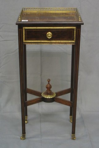 A 19th/20th Century Continental rosewood bedside table with pierced brass three-quarter gallery, inlaid satinwood stringing, fitted a drawer, raised on square tapering supports united by an X framed stretcher  14"