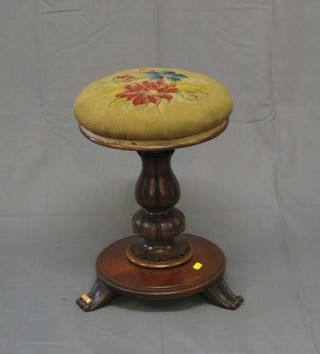 A William IV mahogany revolving adjustable piano stool with Berlin wool work seat, raised on a florette turned column