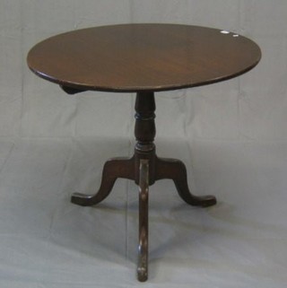 A 19th Century circular oak snap top tea table  raised on a turned column and tripod supports 32"