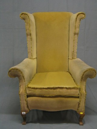 A Georgian style walnutwood framed wing armchair, upholstered green material