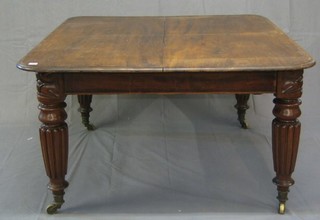 A 19th Century mahogany extending dining table with 2 extra leaves, raised on turned and reeded supports