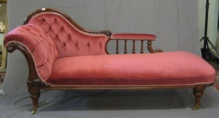 A Victorian carved mahogany show frame chaise longue with bobbin turned decoration upholstered in pink buttoned material, on turned supports 66"