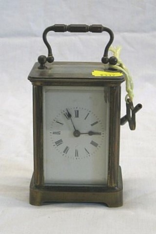 A French 8 day carriage clock with enamelled dial and Roman numerals contained in a gilt metal case