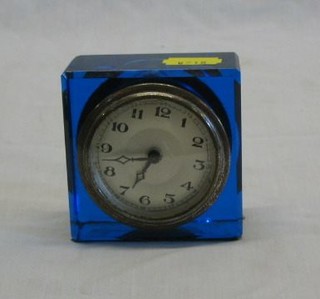 An Art Deco bedroom timepiece with circular silvered dial contained in a blue glass case 3"
