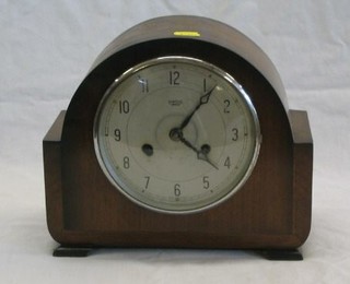A 1930's 8 day striking mantel clock with silvered dial and Arabic numerals contained in an arched walnutwood case