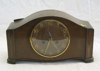 A 1950's 8 day striking mantel clock with gilt Roman numerals contained in an arched oak case
