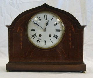 An Edwardian 8 day striking mantel clock with enamelled dial and Roman numerals contained in an arched inlaid mahogany case