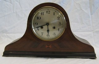 A 1920's 8 day striking mantel clock with silvered dial and Arabic numerals in an inlaid mahogany arched case