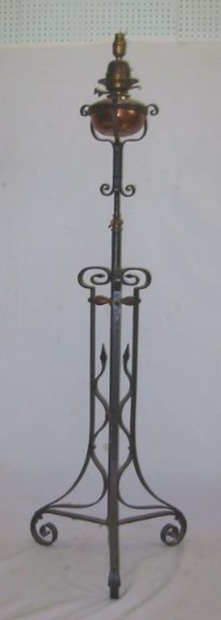 A Victorian wrought iron adjustable standard lamp with copper reservoir