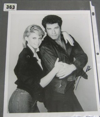 A black and white photograph of John Travolta and Olivia Newton John, signed only by Travolta