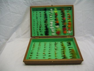 A collection of various flies contained in a wooden canteen box