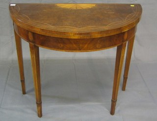 A 19th Century style inlaid figured walnutwood demi-lune shaped card table, raised on square tapering supports 36"