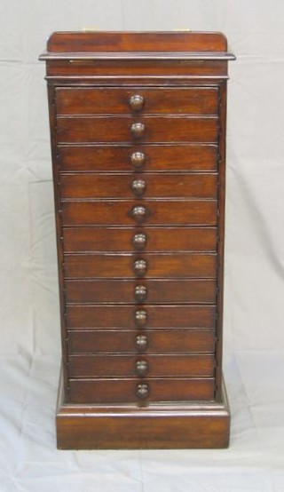 A pedestal collectors or music chest with hinged reading slope, fitted 12 drawers with tore handles, raised on a platform base 17"