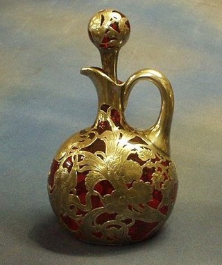 An Art Nouveau ruby glass claret jug and stopper with silver overlay decoration 10"