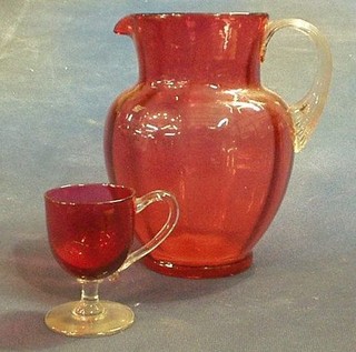A Victorian cranberry glass ewer with clear glass handle 8" together with a cranberry glass custard cup