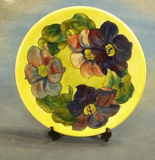 A circular Moorcroft Clematis patterned charger, the base impressed Moorcroft Made In England and with signature mark and paper label 11"