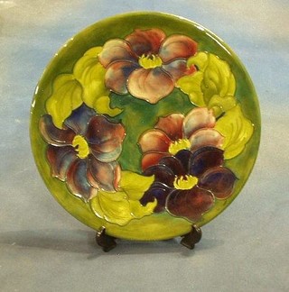 A circular Moorcroft Clematis patterned charger, the base impressed Moorcroft Made in England and with signature mark, 11"
