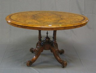 A Victorian oval figured walnutwood  Loo table, the top with crossbanding and satinwood stringing, raised on 3 turned columns and scrolled feet 46"