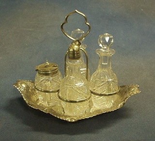 An embossed silver plated boat shaped cruet frame with 5 cut glass bottles raised on bun feet 