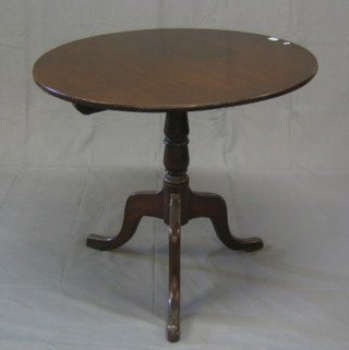 A 19th Century circular oak snap top tea table  raised on a turned column and tripod supports 32"
