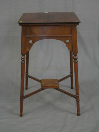 An Edwardian mahogany work table with hinged lid fitted a well, raised on turned supports united by an X framed stretcher 17"