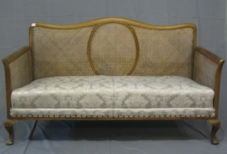 A 1930's 3 piece walnutwood bergere suite comprising 2 seat settee and 2 matching armchairs, on cabriole supports
