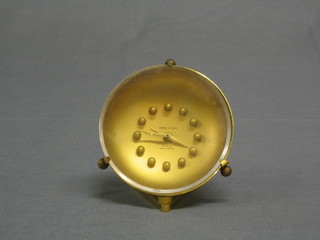 A 1950's alarm clock contained in a circular gilt case by Andre Wyler