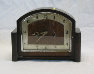 A 1930's 8 day striking mantel clock contained in an arched oak case